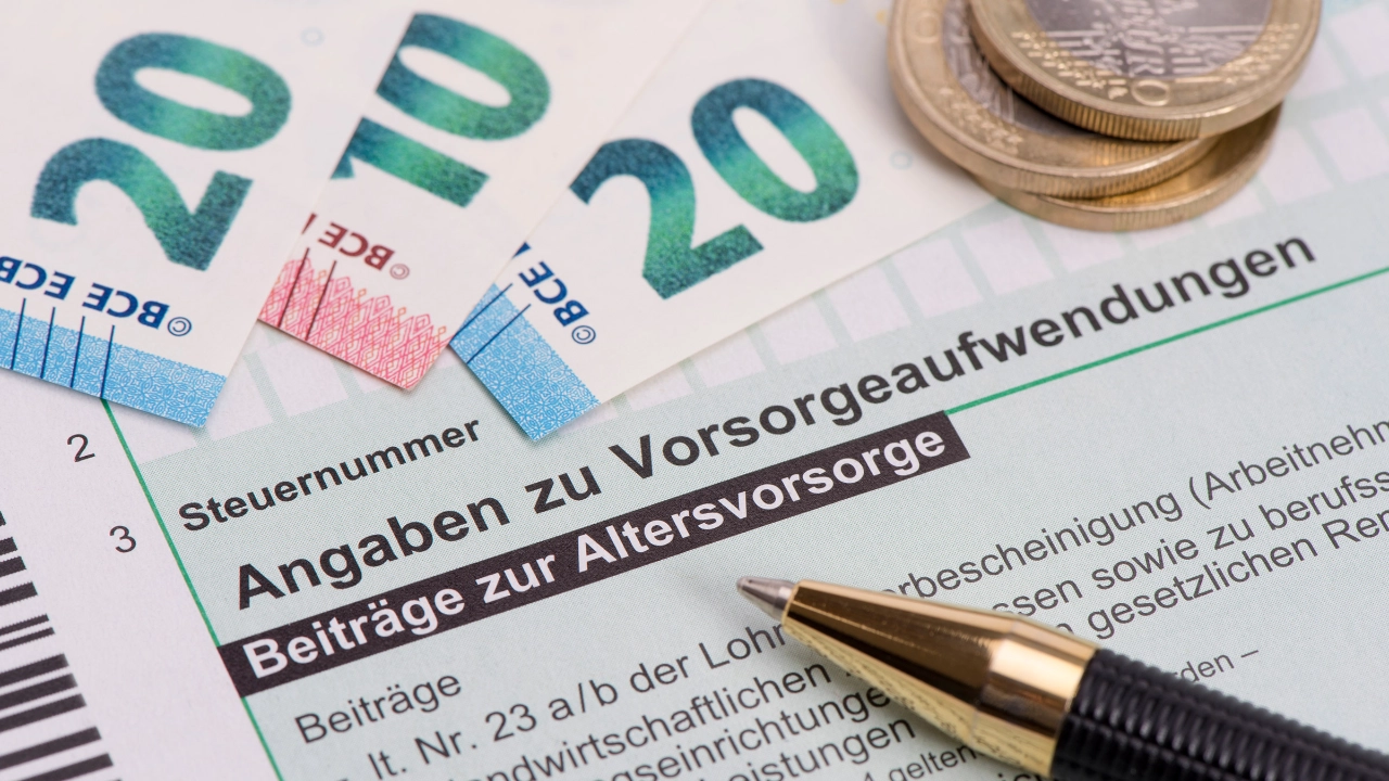 Geldscheine und Münzen liegen auf einem Formular zur Altervorsorge