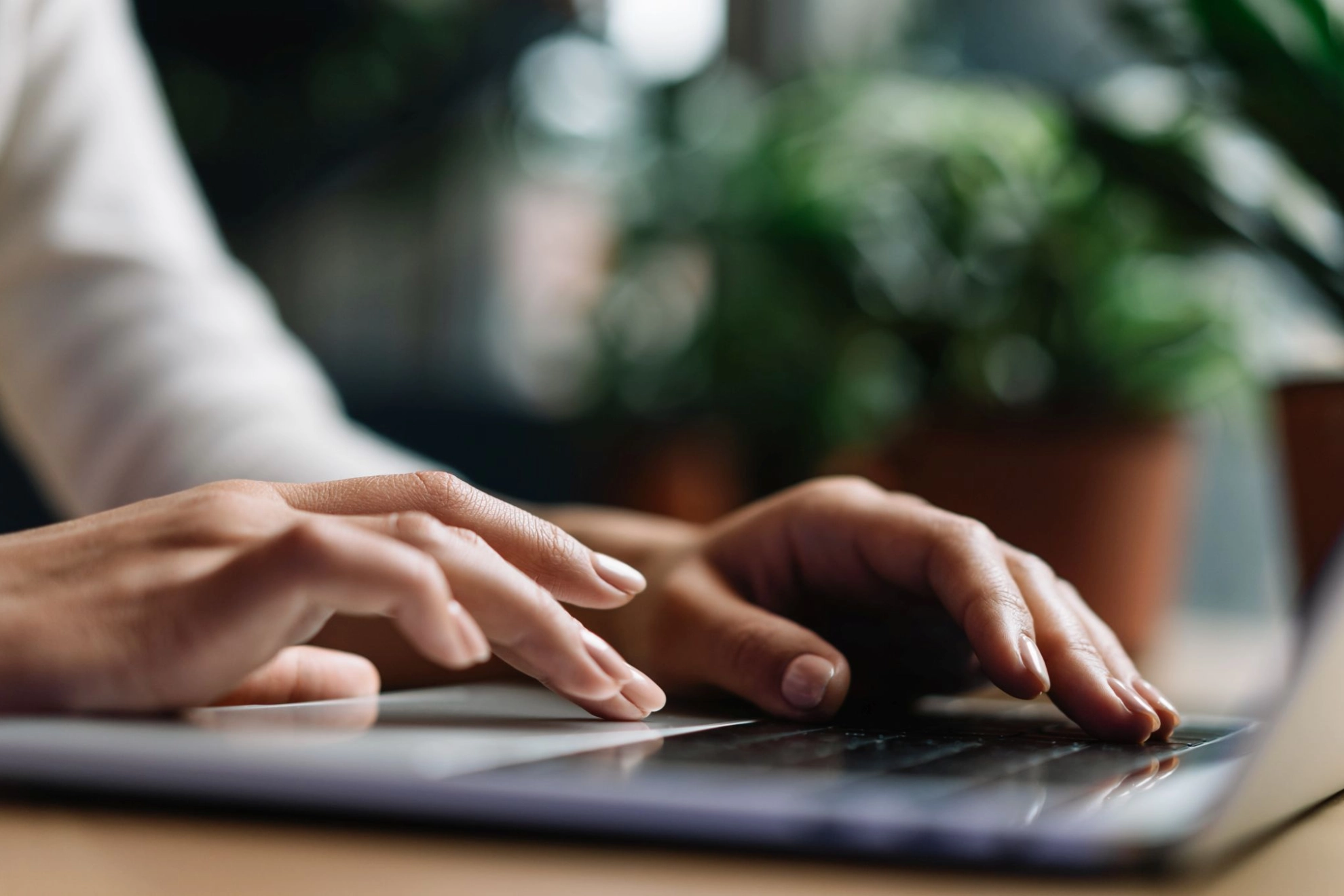 Hände tippen auf der Tastatur eines Laptops