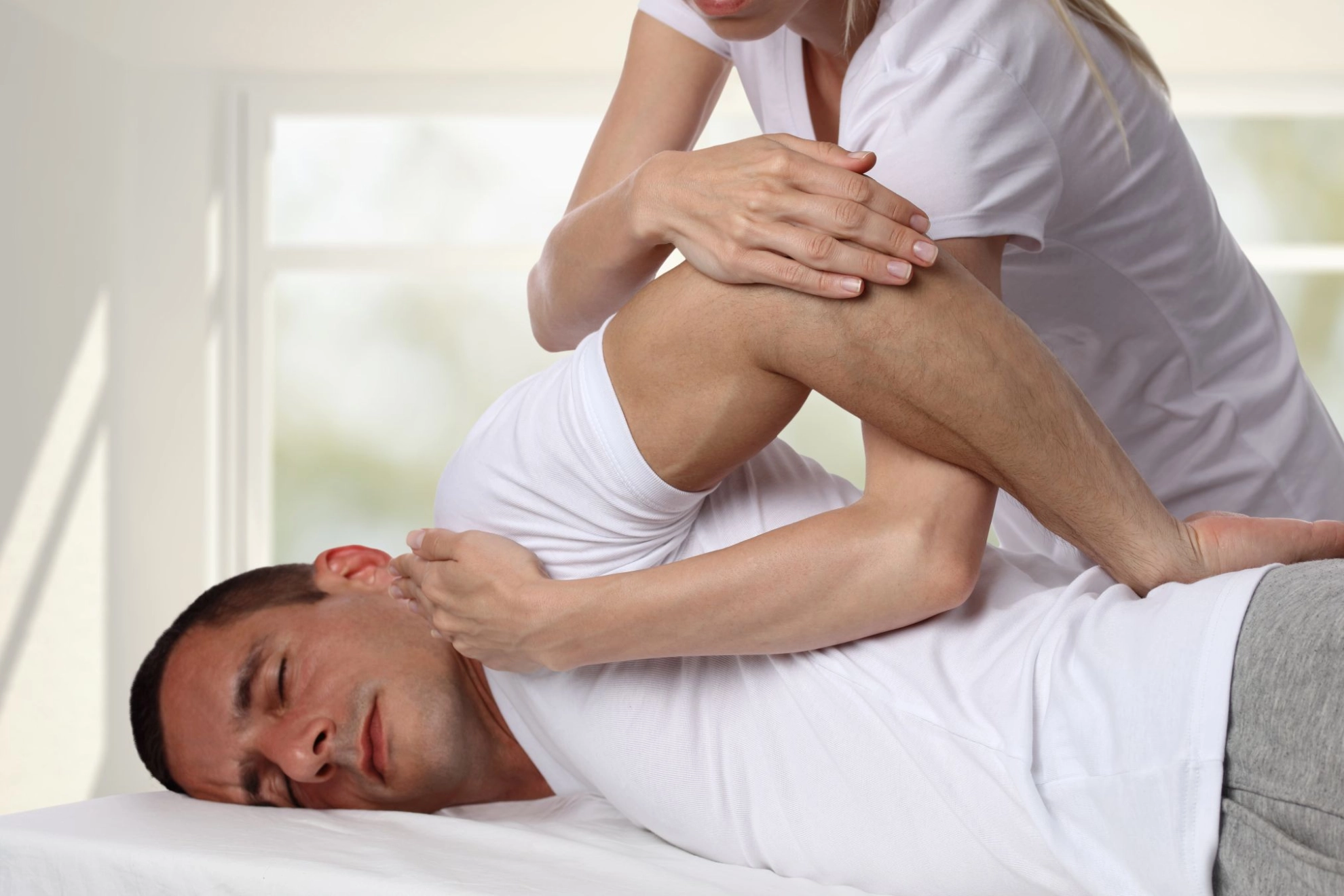 ein Mann lässt sich physiotherapeutisch behandeln